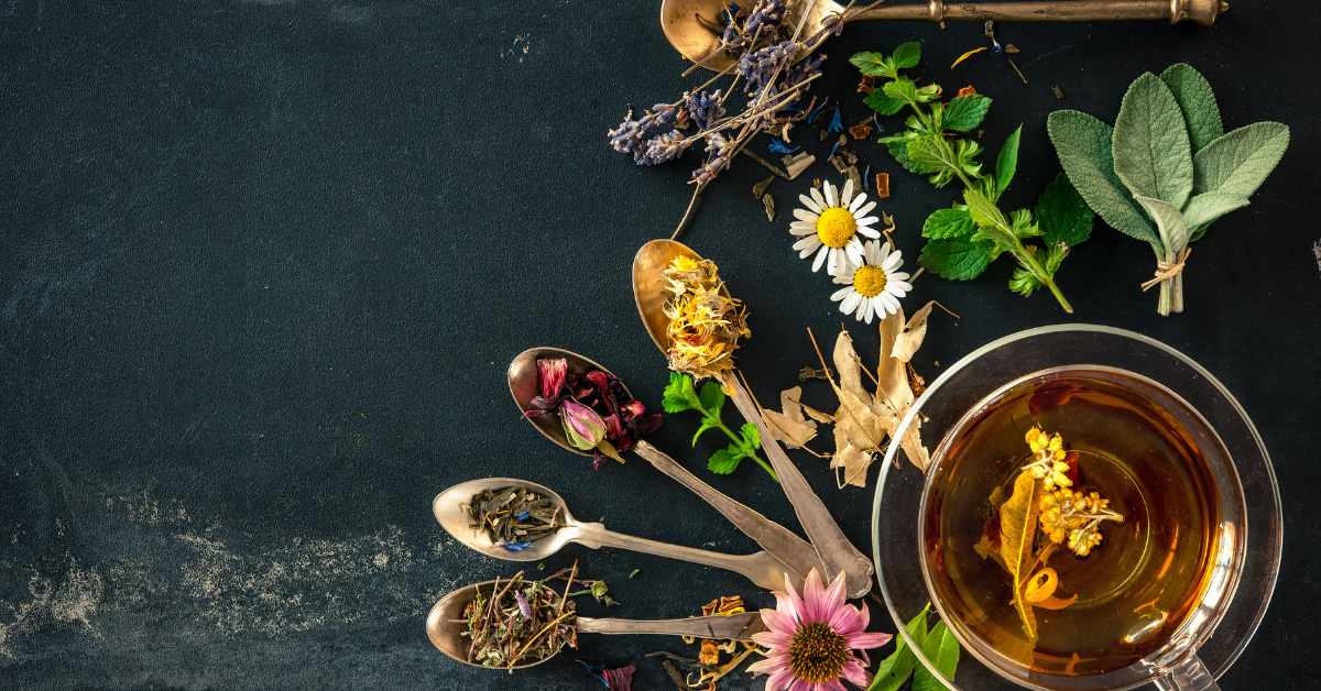 A glass cup of Blood Purifying Spring Tea with assorted dried herbs and flowers, symbolising a natural spring detox blend.